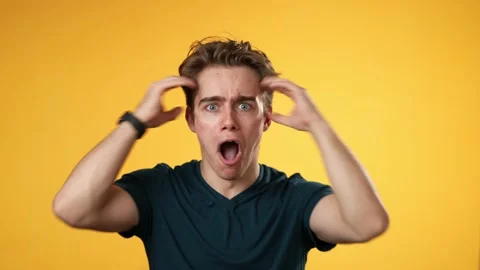 Handsome thinking young man 20s, looks at camera gives mind blown gesture Stock Footage 223259345