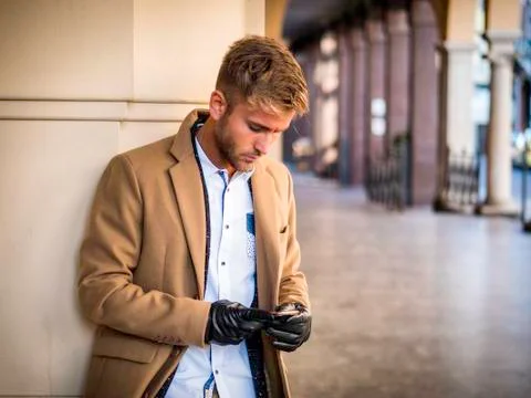 Handsome trendy man using cell phone to type text Stock Photos