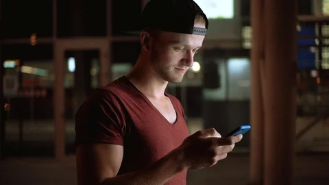 Handsome Ukrainian guy with beard looking at screen of cellphone, smiling. Young Stock Footage 91154804