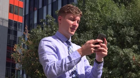 Handsome urban professional business man in the city outdoors texting message 4K Stock Footage