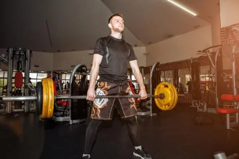 Handsome weightlifter preparing for training. Shallow depth of field, selecti Stock Photos