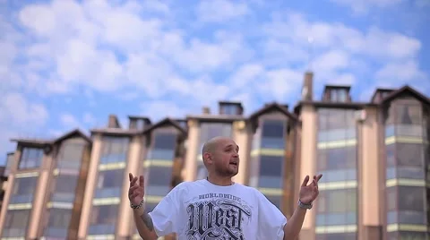 Handsome White Man Rapping on the Background of Multi-Storey Buildings and Stock Footage 66692088