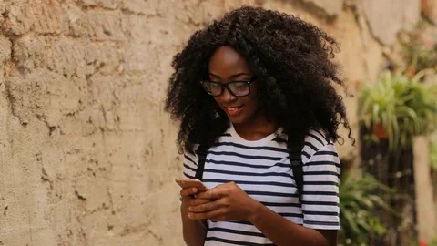 Handsome woman in the glasses using smart phone for chatting with friend while Stock Footage 78984300