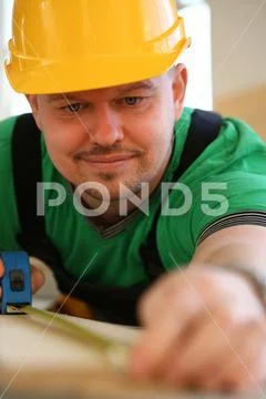 Handsome worker measuring. Manual Stock Photos