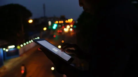 Handsome, young asain man with tablet computer in city at night Stock Footage 63560268