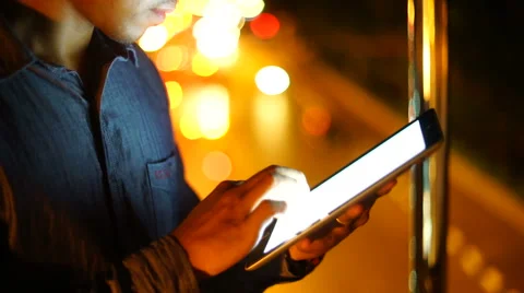 Handsome, young asain man with tablet computer in city at night Stock Footage 63574094