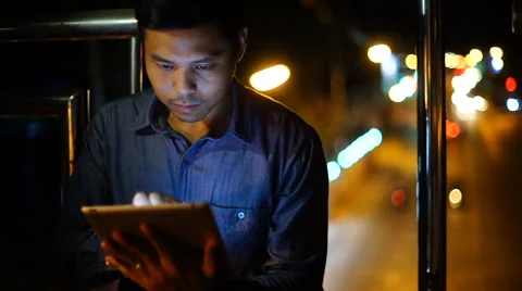 Handsome, young asain man with tablet computer in city at night Stock Footage 63577627