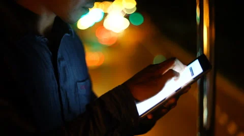 Handsome, young asain man with tablet computer in city at night Stock Footage 63580675