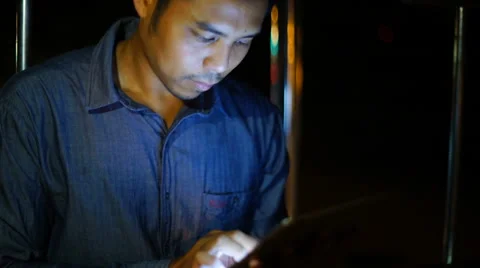 Handsome, young asain man with tablet computer in city at night Stock Footage 63582121