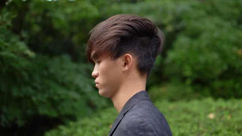 Handsome Young Asian Man Taking Phone Call - Tracking Shot Stock Footage 104997364