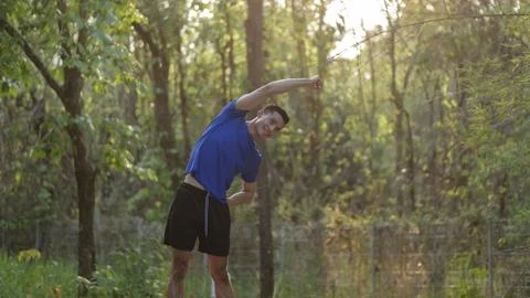 Handsome young athletic man warming up before exercise in morning. Healthy .. Stock Photos