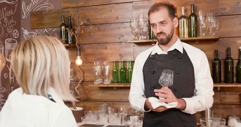 Handsome young bearded bartender listens to the waitress at the bar Stock Footage 104866964