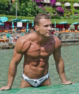 Handsome young bodybuilder on the beach Stock Photos