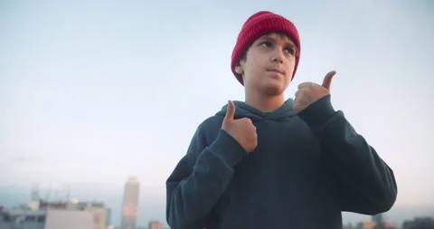 Handsome young boy dancing and have fun on rooftop at sunset. Wearing hoody and 스톡 동영상 139595380