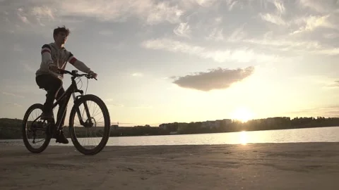 Handsome young boy in the sunset on the bicycle Stock Footage 130473052