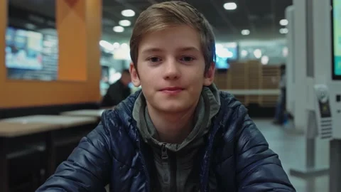 Handsome Young Boy Talks During Conference Video Call in cafe. Looks into Camera Stock Footage 145419721