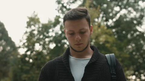 Handsome young business man talking on smartphone and walking away smiling happy Stock Footage