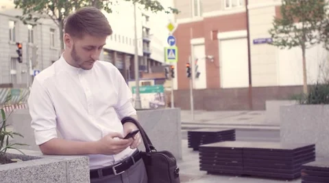 Handsome young business man using smartphone happy outdoors. Man texting using Stock Footage 66456669