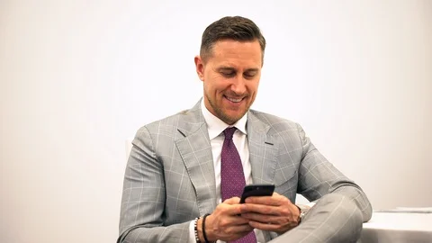 Handsome young business man using smartphone smiling happy wearing suit jacket Stock Footage 94838187