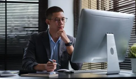 Handsome young businessman working with computer at office.. Stock Photos
