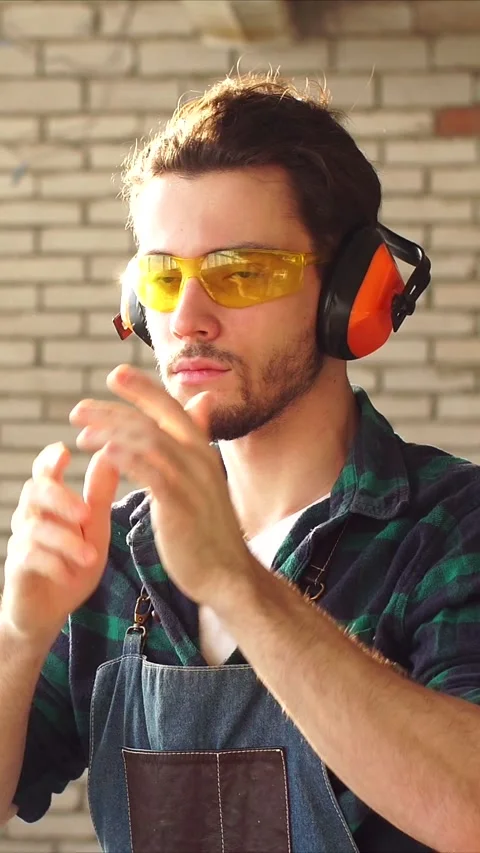 Handsome young carpenter confidently poses at camera in bright studio against of Stock Footage 322972477
