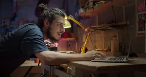 Handsome young carpenter using laptop connected working with wooden planks on Stock Footage 137242781