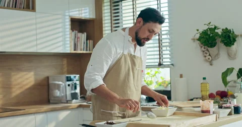 Handsome young chef in apron preparing dough for pizza on wooden surface Stockbeeldmateriaal 218639759