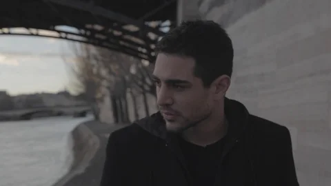 Handsome young depressed man walking on the banks of the Seine in Paris winter Stock Footage 110914432