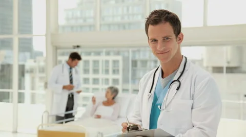 Handsome Young Doctor Taking Notes in a Hospital Room Video stock 891593