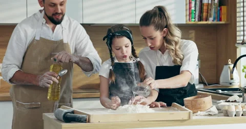 Handsome young father in apron clapping in hands with flour taking oil pouring Stock Footage 218631394