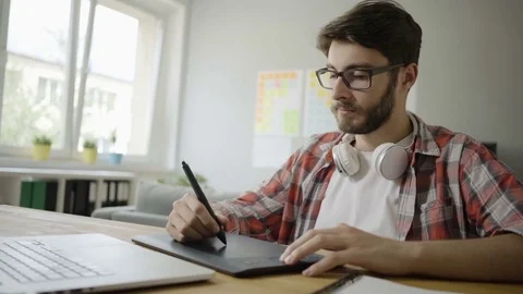 Handsome young graphic designer working in home office using graphics tablet Stock Footage 79801559