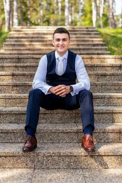 Handsome young groom wearing elegant and stylish dark blue suit outdoors port Stock Photos