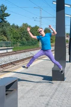Handsome young guy jumping on train station Stock Photos