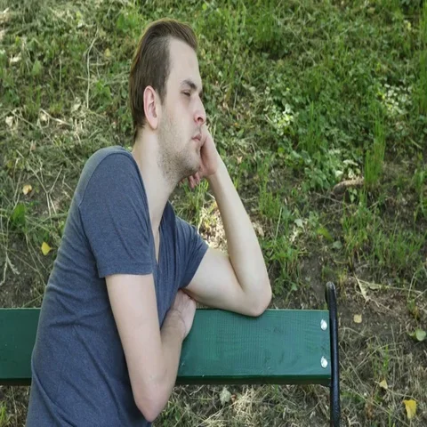 Handsome Young Guy Looking Sad and Pensive Park Bench Negative Thinking Concept Stock Footage 69706705