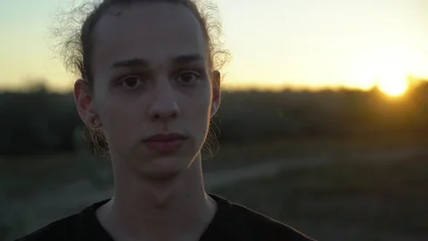Handsome young guy at sunset on the nature bg, close up,4k Vidéo 98501554