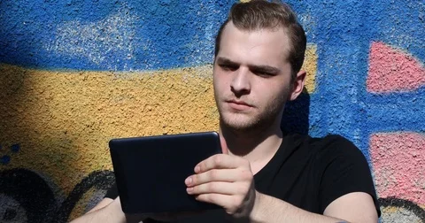 Handsome Young Guy Surfing Internet Using Digital Tablet Attractive Man Relaxing Stock Footage 73572219