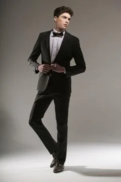 Handsome young guy trying to button up his jacket Fotos Stock