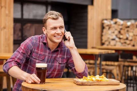 Handsome young guy is using telephone in bar Stock Photos
