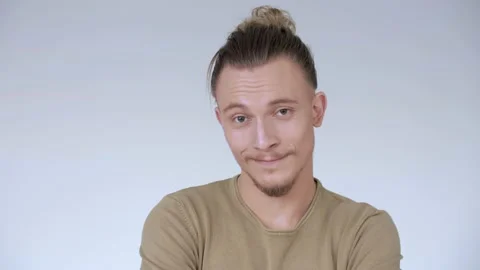 Handsome young hipster guy looking at the camera with charming smile. White Vídeo Stock 141459369