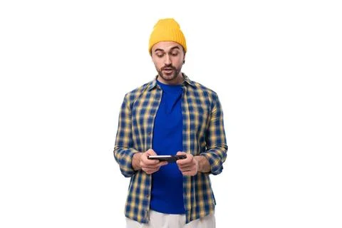 Handsome young hipster man in cap and shirt chatting in smartphone on white Stock Photos