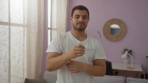 Handsome young hispanic man inside a cozy apartment living room adjusting e.. Video stock 288430932