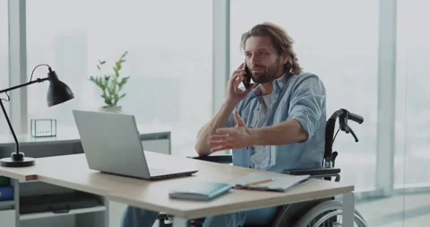 Handsome young invalid disabled man business guy talking on mobile phone in Stock Footage 149181574