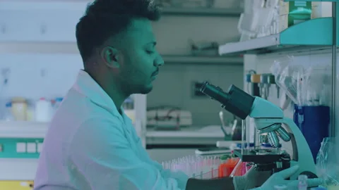 Handsome Young Lab Assistant Putting a Petri Dish Under a Microscope Stock Footage 164991424