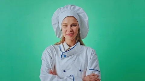 Handsome young lady baker posing in front of the camera inside of a green studio Stock Footage 125481899