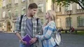 Handsome young male and female standing near college and talking, students 4k or 4k+ Resolution