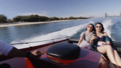 Handsome young man and two beautiful young women wearing sunglasses cruising on Stock Footage 199457237