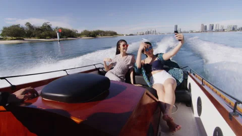 Handsome young man and two beautiful young women wearing sunglasses cruising on Video stock 199461746