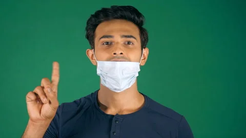 Handsome young man avoiding taking off the medical mask during Coronavirus Stock Footage 161774101