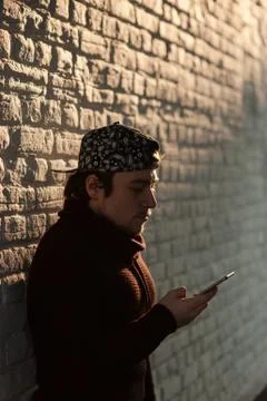 Handsome young man in a baseball cap with a smartphone online Foto stock