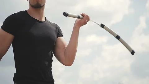 Handsome, young man with a beard in a black T-shirt demonstrates mastery with 库存影片 119470562